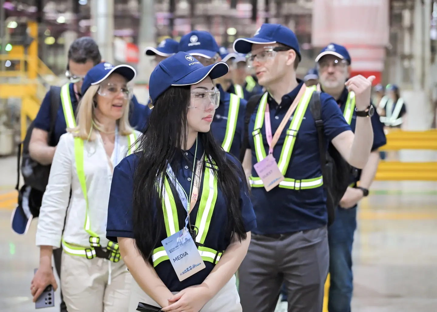 A group of visiting buyers in hi-vis vests walking a factory floor in China with Flawless Effect
