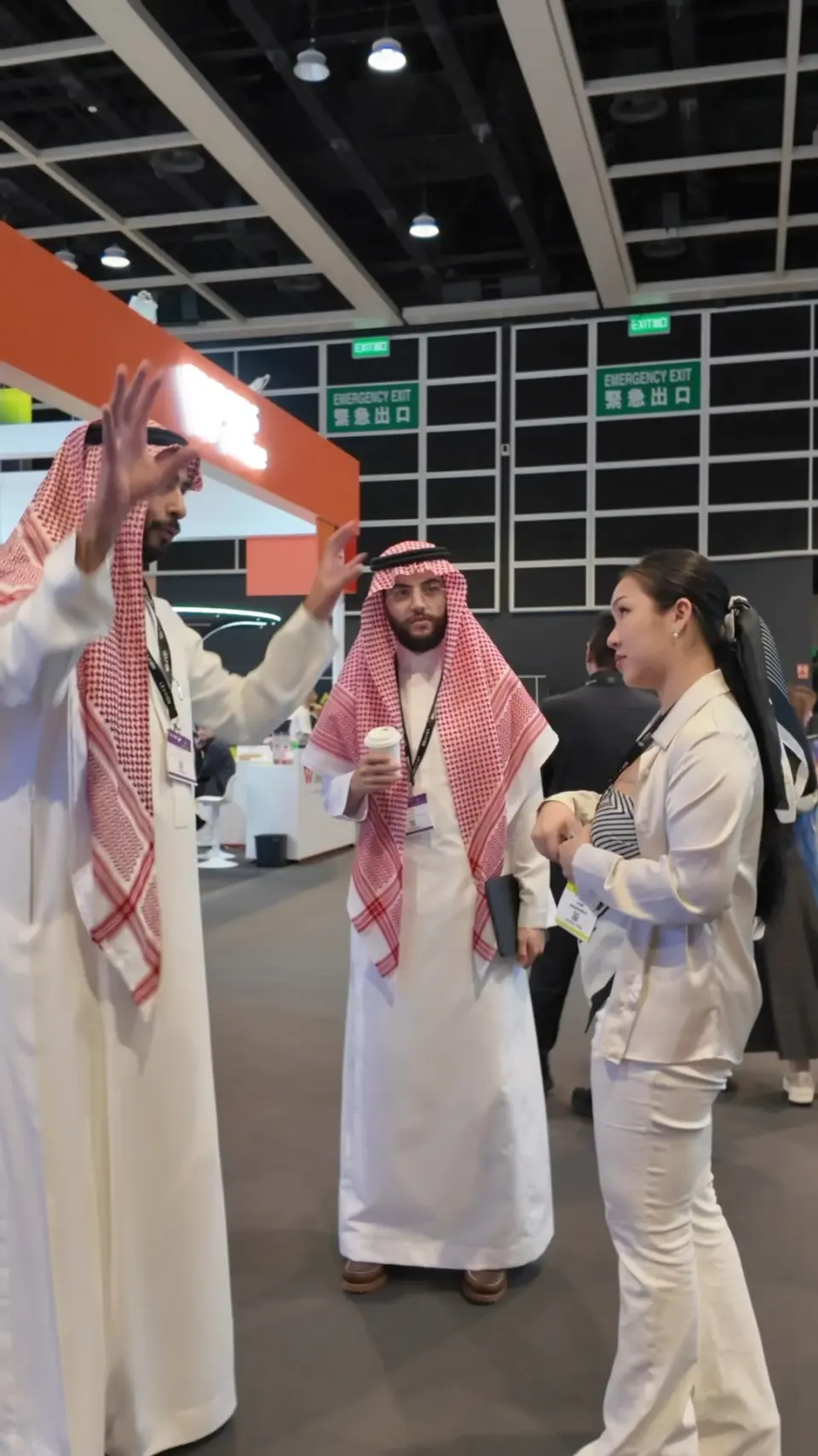 Flawless Effect in conversation with buyers wearing traditional Gulf dress at a trade exhibition
